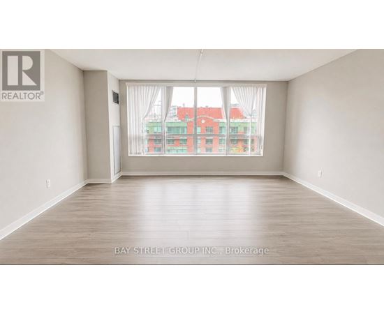 A spacious room with a view of a red building across the street.
