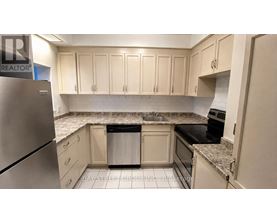 A kitchen with a refrigerator and cabinets.