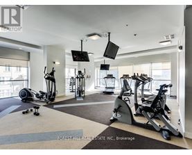 A gym with a variety of equipment including treadmills, stationary bikes, and elliptical machines.