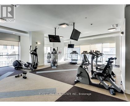 A gym with a variety of equipment including treadmills, stationary bikes, and elliptical machines.