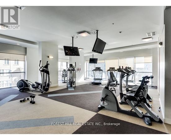 A gym with a variety of equipment including treadmills, stationary bikes, and elliptical machines.