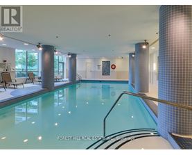 A swimming pool inside a building with a glass wall.