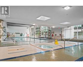 A large indoor swimming pool with a yellow caution sign in the middle.