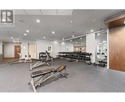 A gym with a variety of equipment including weights and benches.