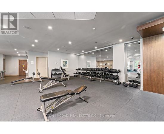 A gym with a variety of equipment including weights and benches.