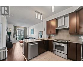 A modern kitchen with brown cabinets and stainless steel appliances.