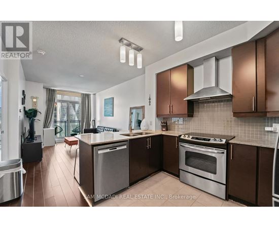 A modern kitchen with brown cabinets and stainless steel appliances.