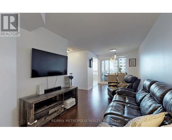 A living room with a black leather couch and a wooden entertainment center.