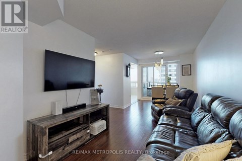 A living room with a black leather couch and a wooden entertainment center.
