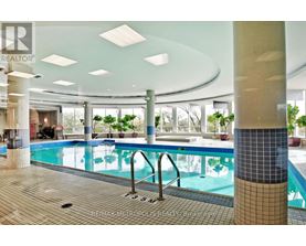 A large indoor swimming pool with a tiled edge and a metal ladder.