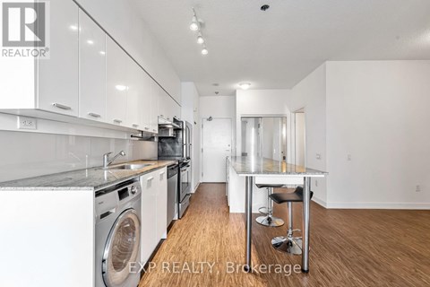 A modern kitchen with white cabinets and stainless steel appliances.