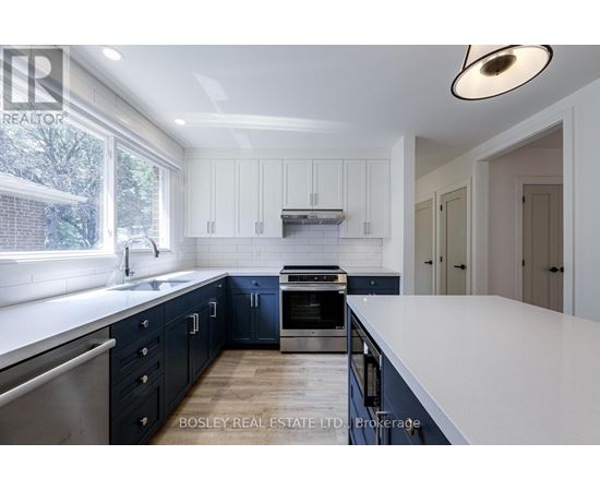 A modern kitchen with dark blue cabinets and a white island.