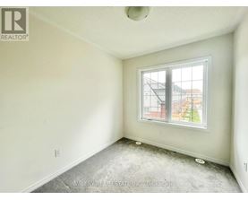 A room with a window and a view of a building outside.