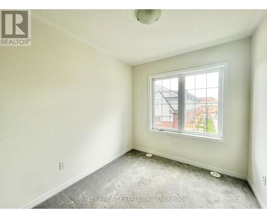 A room with a window and a view of a building outside.