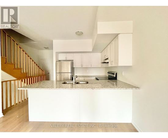 A kitchen with white cabinets and a granite countertop.