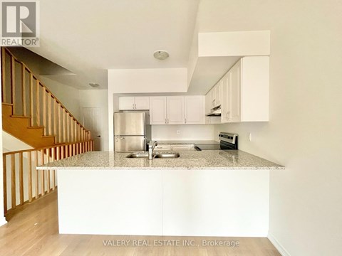 A kitchen with white cabinets and a granite countertop.