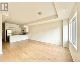 A spacious room with wooden flooring and white walls.