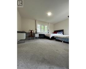 A bedroom with a bed, chair, and desk.
