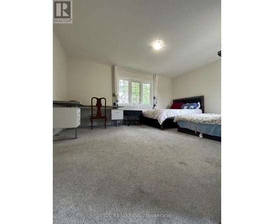 A bedroom with a bed, chair, and desk.