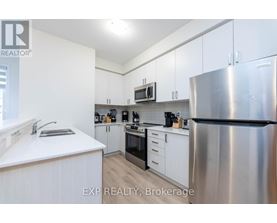 A kitchen with white cabinets and a stainless steel refrigerator.