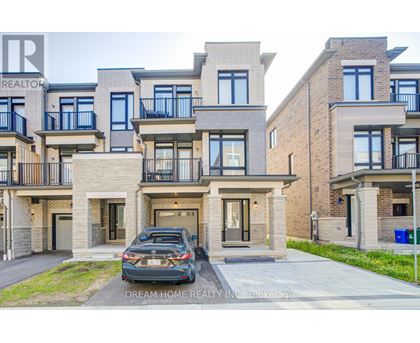 A modern two-story residential building with a car parked in front.