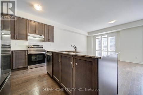 A modern kitchen with wooden cabinets and stainless steel appliances.
