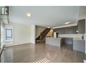 A spacious living room with a staircase leading to the upper floor.
