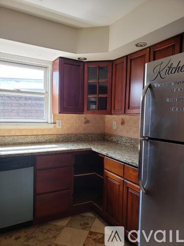 A kitchen with brown cabinets and a refrigerator.