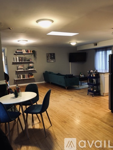 A living room with a couch, chairs, and a television.