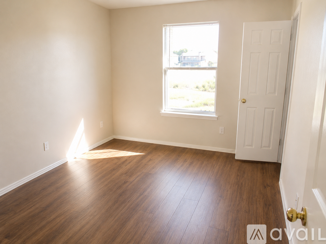 A room with a white door and a window with sunlight shining through.