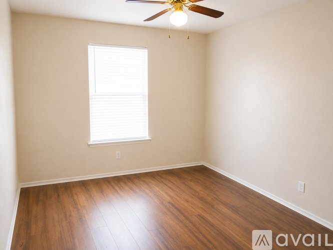 A room with a ceiling fan and a window.