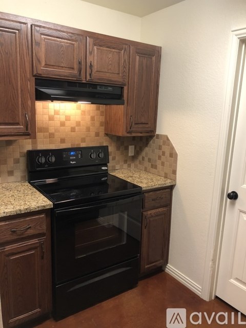 A kitchen with wooden cabinets and a black stove top oven.