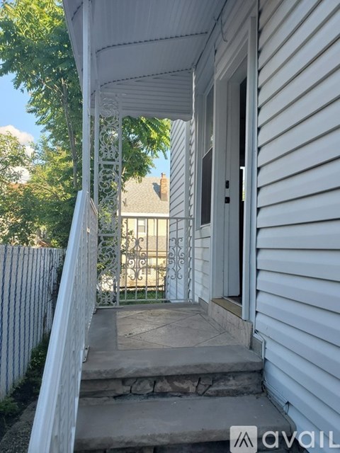 A white house with a porch and a white fence.