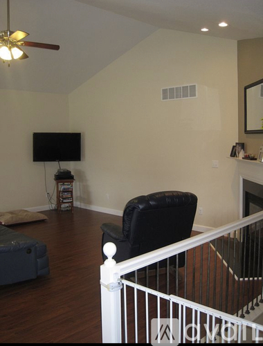 A living room with a black chair and a television.