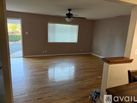 A room with wooden flooring and a ceiling fan.