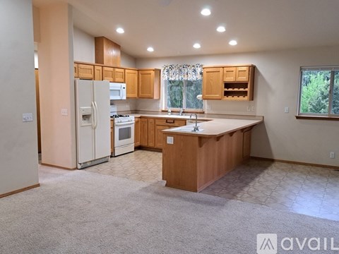 A kitchen with wooden cabinets and a white refrigerator.