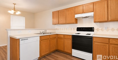 A kitchen with wooden cabinets and a white dishwasher.