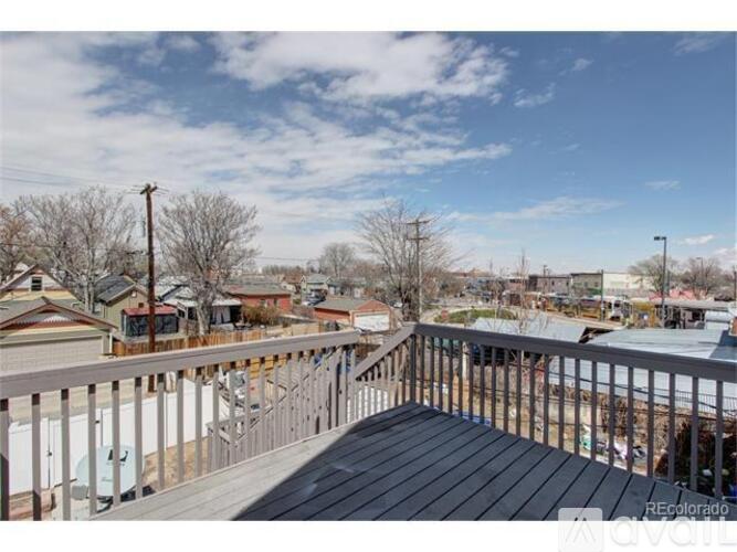 A balcony overlooks a residential area with houses and bare trees.