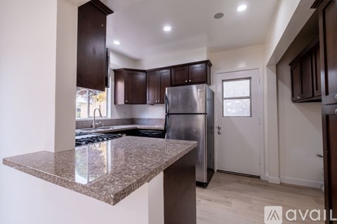 A kitchen with brown cabinets and a granite countertop.