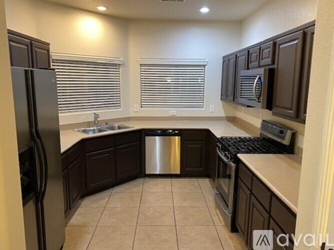 A kitchen with brown cabinets and a stainless steel refrigerator.