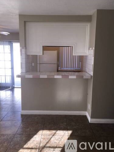 A kitchen area with a counter and cabinets.