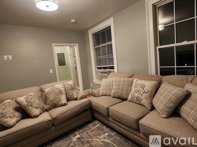 A living room with a couch and pillows.