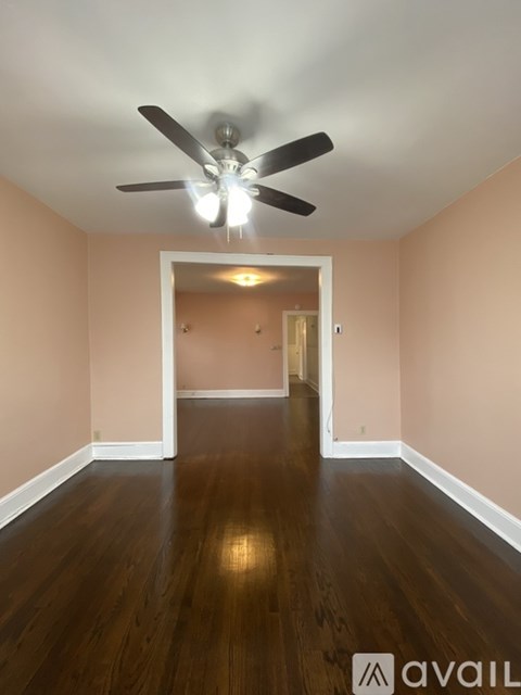 A room with a ceiling fan and wooden floors.