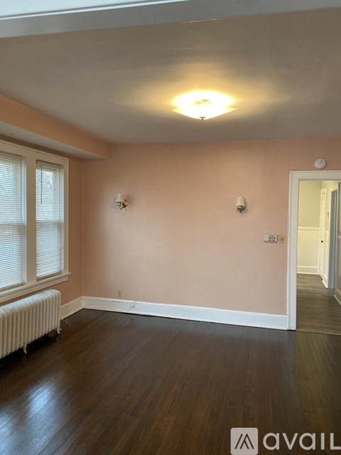 A room with wooden floors and two wall sconces.