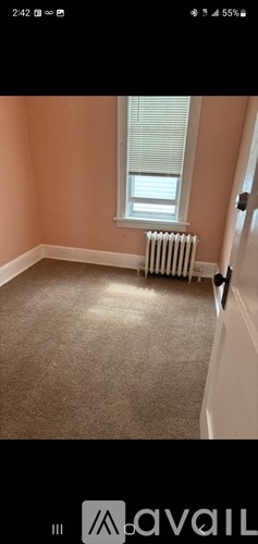 A room with a window and a radiator on the floor.