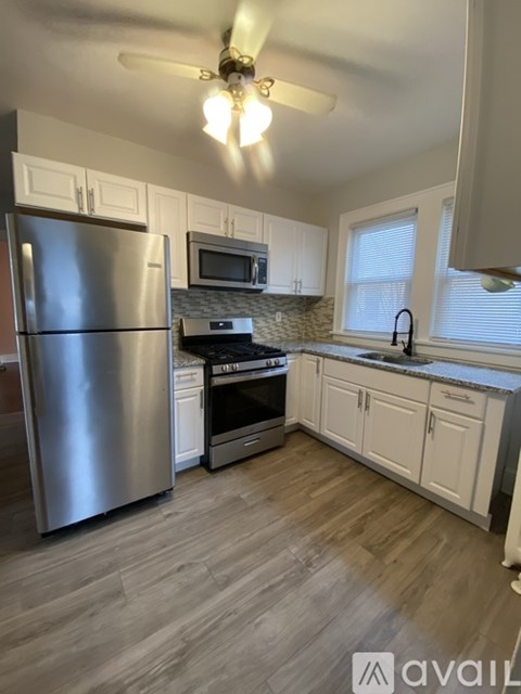 A kitchen with a stainless steel refrigerator, microwave, oven, and cabinets.