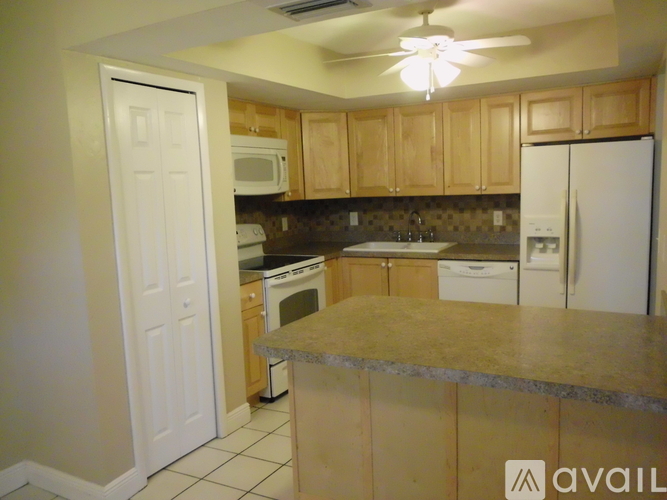 A kitchen with a white refrigerator and wooden cabinets.