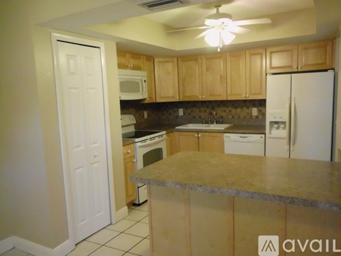 A kitchen with a white refrigerator and wooden cabinets.