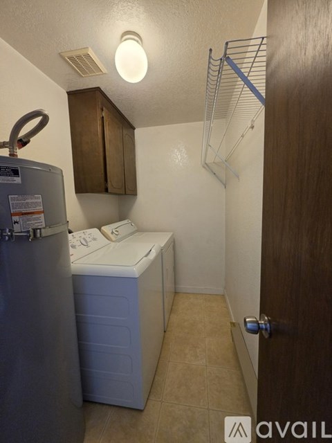 A small kitchen with a fridge and a washing machine.