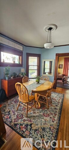 A dining room with a wooden table and chairs.